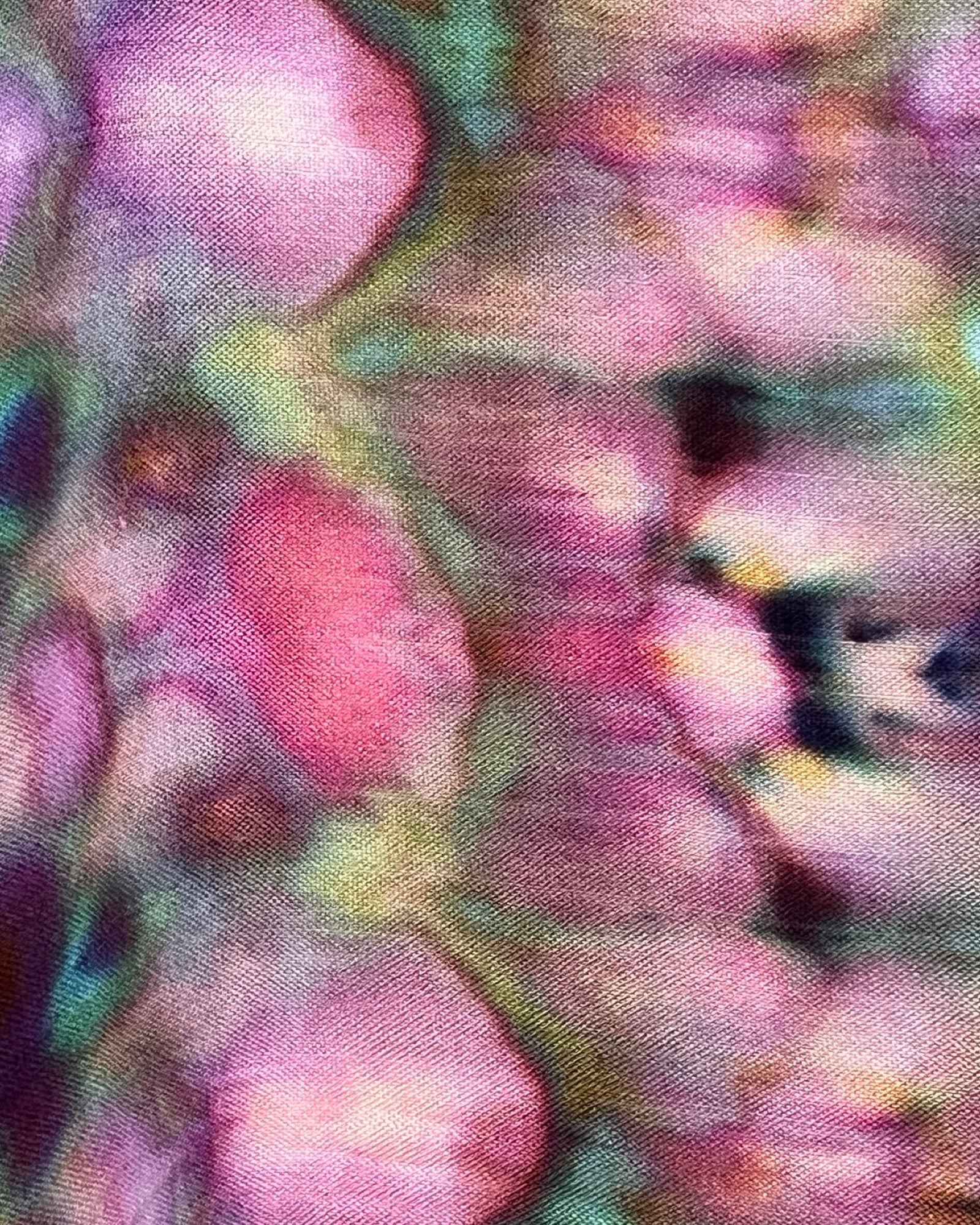 Close-up of a tie-dye pattern with pink, green, and purple colors.